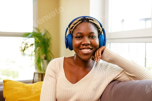 Preview: latin hispanic woman listen music while sitting on sofa in living room