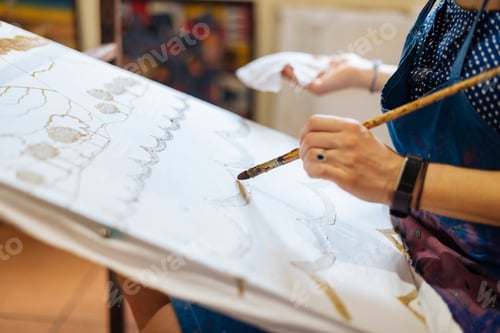 Preview: An artist meticulously brings color to canvas in a bright studio setting.