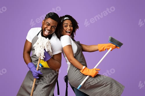 Preview: Positive black couple enjoying cleaning together, having fun with mop and broom