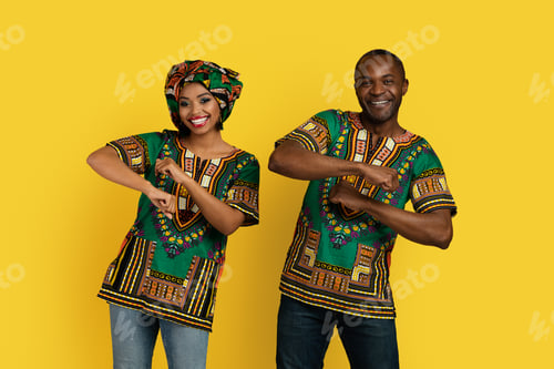 Preview: Cheerful black man and woman in african costumes dancing together