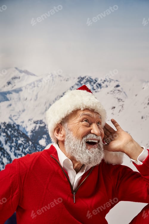 Preview: portrait of white bearded jolly Santa in red festive hat posing with hand near face, winter concept