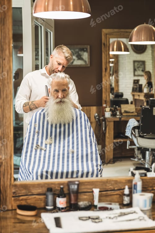 Preview: Hairdresser making stylish haircut for a handsome old man