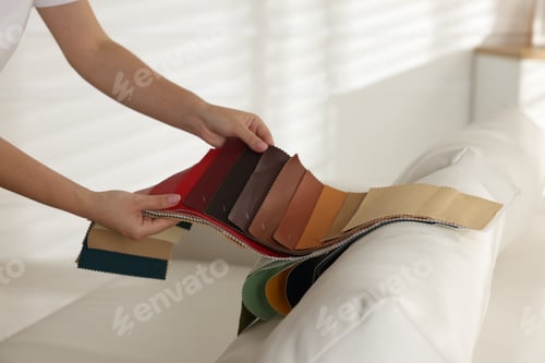 Preview: Woman choosing fabric among different samples at home, closeup