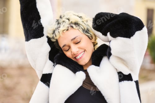 Preview: Young woman smiling with eyes closed feeling happiness