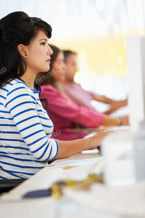 Preview: Woman Working At Desk In Busy Creative Office