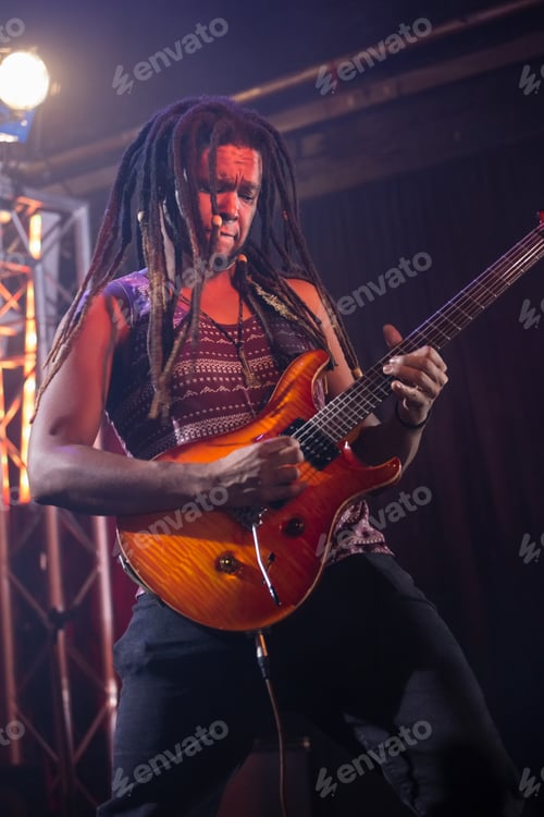 Preview: Playing electric guitar on stage, musician performing passionately at live concert