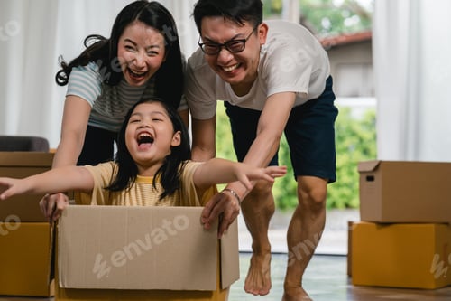 Preview: Happy Asian young family having fun laughing moving into new home.