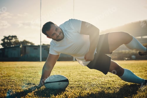 Preview: Cropped shot of a handsome young rugby player training on the field during the day