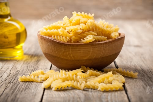 Preview: Bowl of uncooked pasta with oil bottle