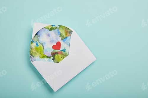 Preview: top view of envelope with planet picture on turquoise background, earth day concept