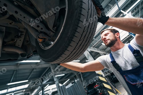 Preview: Mechanic Inspects Car Tire in the Auto Repair Shop