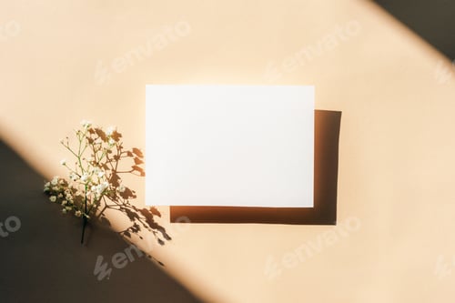 Preview: White blank card with small white flowers and shadows on beige background. Minimal mockup