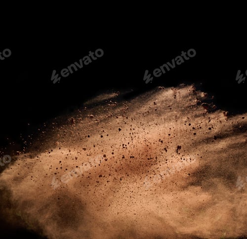 Preview: Flying brown cocoa particles on a black background. Powder flies up