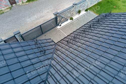 Preview: Closeup of house roof top covered with shiny ceramic shingles.