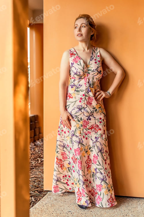 Preview: A woman in a long dress near the orange wall