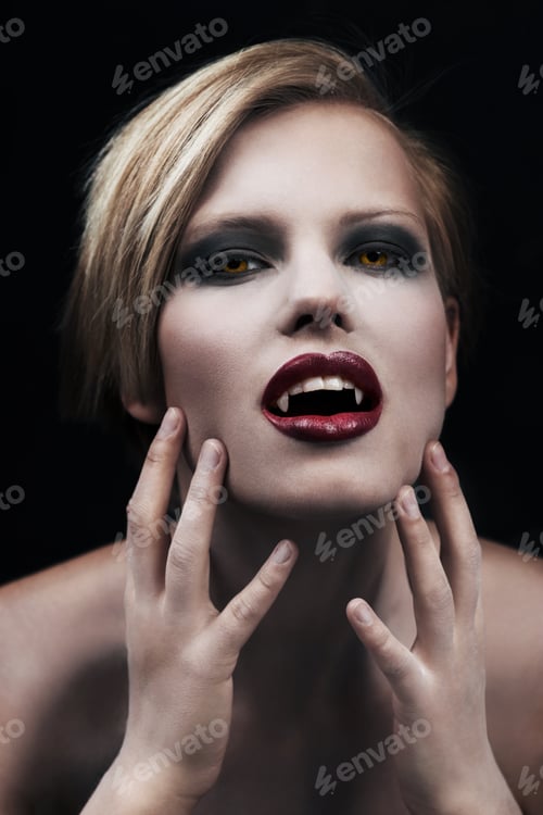 Preview: Creature of the night. A seductive female vampire with blood red lips against a dark background.
