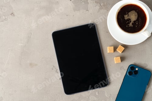 Preview: Digital tablet and coffee cup on gray background close up