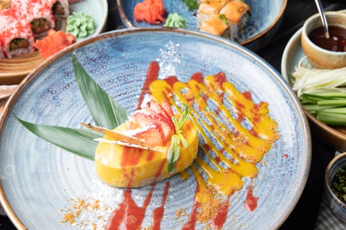 Preview: side view of mango cheesecake decorated with fresh strawberry on a plate
