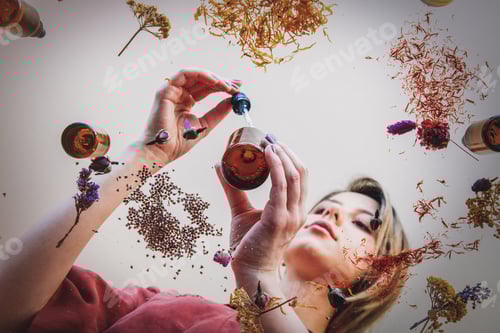 Visualização: perfumista mulher preparando ervas e flores para fazer um perfume.