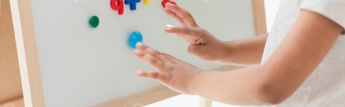 Preview: horizontal crop of african american kid touching magnetic easel with magnets
