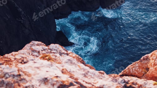 Preview: Beautiful overhead shot of body of water with amazing textures hitting the cliffs in the sea