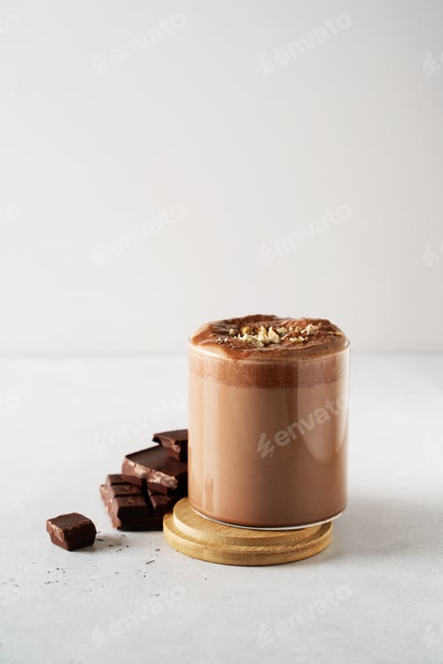 Preview: Protein chocolate cocktail drink in glass with powder and scoop