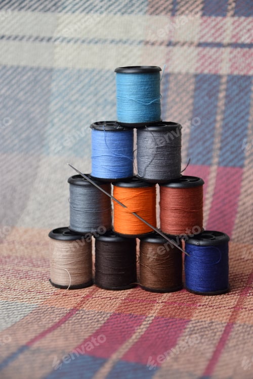 Preview: earthen and fall coloured thread on woven fabric background