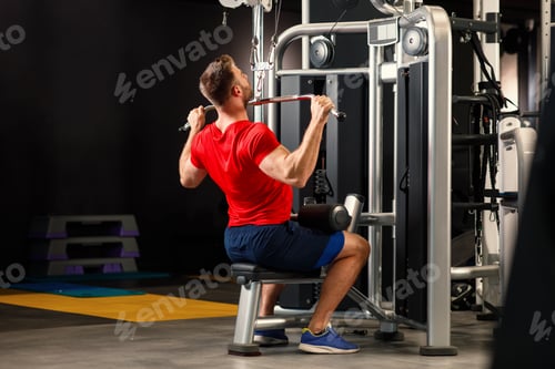 Preview: Young muscular man pulling up on horizontal bar in a gym