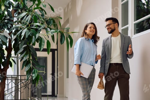 Aperçu: Happy entrepreneurs talking while working at modern office.