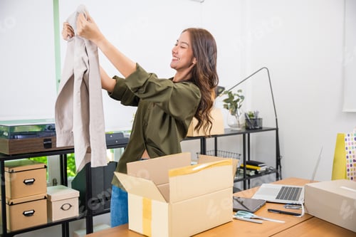Preview: Happy Asian woman customer opening box after ordered new fashion clothes at home