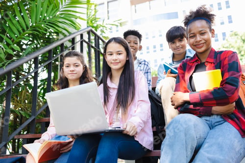 Preview: Back to school concept. portrait of diverse students sitting on the staircase at the school.