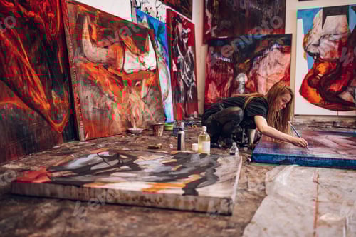 Preview: Female painter artist painting and creating her art in a creative studio