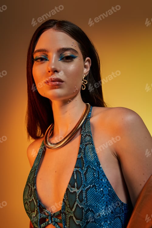 Preview: A young woman enthralls with her bold makeup and stylish snake print outfit.