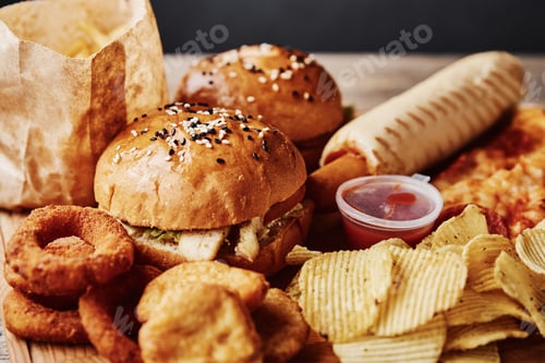Preview: Unhealthy and junk food. Different types of fastfood and snacks on the table, closeup. Takeaway food