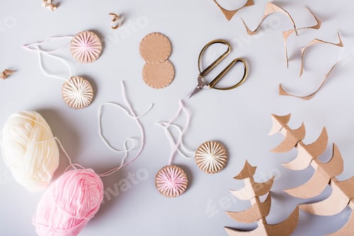 Preview: DIY Christmas handmade decorations made of cardboard and yarn on the table. Top view.