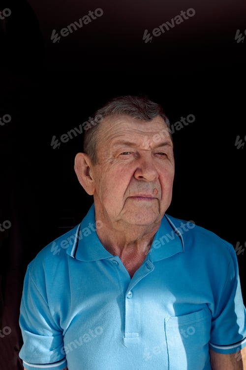Vorschau: Porträt eines traurigen älteren Mannes auf schwarzem Hintergrund. Nachdenklicher Blick eines alten Senioren, der alleine zu Hause sitzt