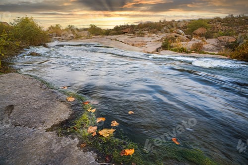 Preview: A small shining stream flows among smooth wet and dark stones
