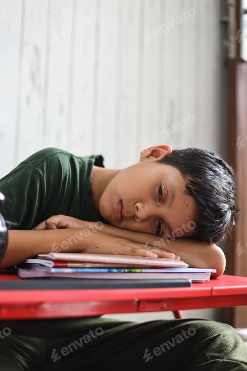 Preview: Schoolboy tired of learning, doing homework