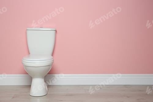Preview: New ceramic toilet bowl near color wall with space for text