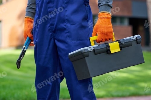 Preview: Ready for renovation work. Close up of builder carrying toolbox at construction site