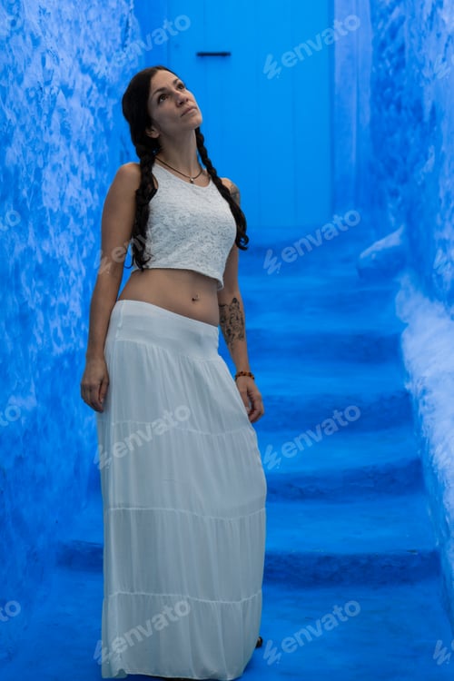 Preview: Young woman looking on blue wall