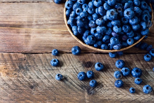 Preview: Blueberries on wooden table. Blueberry bowl on vintage background with copyspace. Berries frame