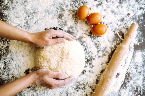 Preview: Making dough by female hands on wooden table background. Cooking concept. Lovely female hands.