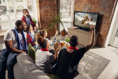 Preview: Excited group of people watching sport match at home