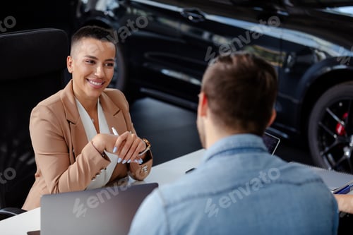 Preview: Beautiful smiling car dealer helping young man to buying a new car.