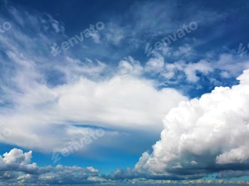Vorschau: Dynamische Wolkenlandschaft vor einem strahlend blauen Himmel.