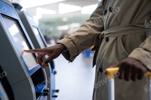 Preview: Black traveler man using self check-in machine kiosk service at airport, finger point on display