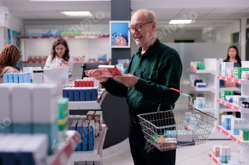 Preview: Senior client looking at drugs package during medication shopping