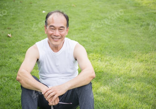 Preview: Cheerful Man Sits on Green Grass Smiling