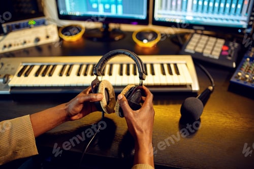 Preview: Sound engineer holds headphones, recording studio